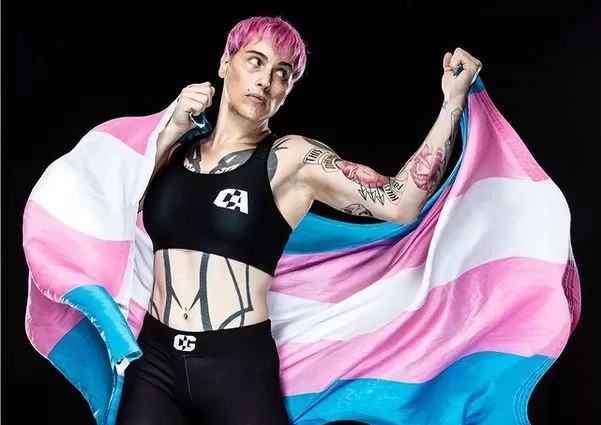 Alana McLaughlin, throwing a punch holding the trans flag